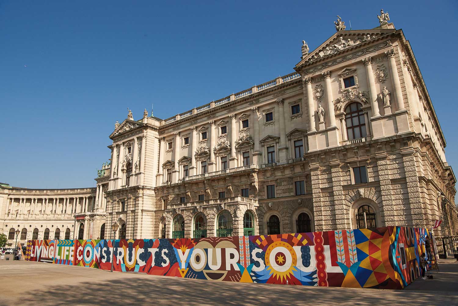 Der Bauzaun rund um das Weltmuseum Wien wurde von den spanischen Urban Artists „Boa Mistura“ gestaltet. Es trägt die Worte des Seefahrers James Cook und enthält Elemente die an die Ausstellungsstücke des Museums erinnern. (Foto: © KHM-Museumsverband).