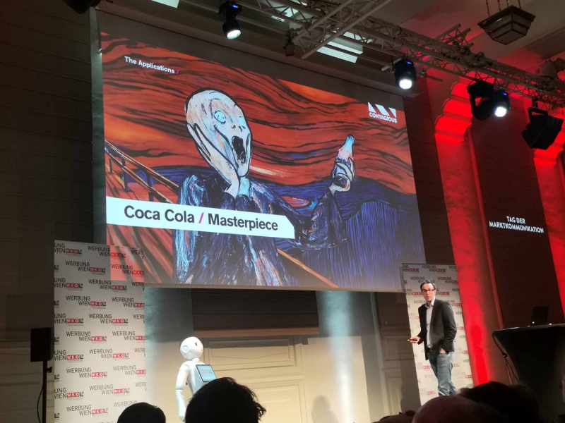 Estratega David Beresford cuando presentaba su ponencia en el "Tag der Marktkommunikation 2023". En la pantalla una imagen de 'Masterpiece', el nuevo anuncio global de Coca-Cola que presenta la pintura icónica de Andy Warhol con una botella del famoso líquido negro.